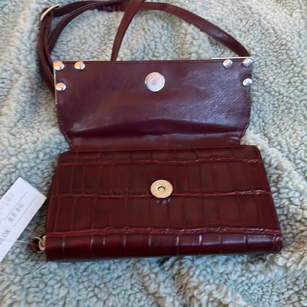 Small burgundy wallet with silver details.